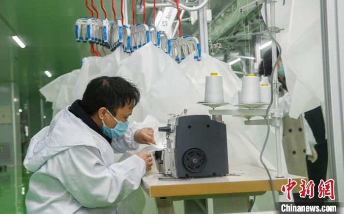 工人生產(chǎn)防護(hù)服，保障抗疫物資供應(yīng)。廣安市委宣傳部供圖