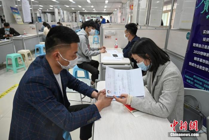 4月14日，招聘者在查看求職者簡(jiǎn)歷。<a target='_blank'  data-cke-saved- >中新社</a>記者 王剛 攝